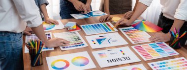 Grafik tasarımcı beyin fırtınası logosu ve grafik sanat yoğun yaratıcı stüdyo atölyesinde. Yaratıcı tasarım için çalışma masasında deney ve beyin fırtınası renk paleti ve desen. Panorama çekimi. İnceleyin