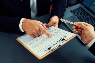 Kapanış toplantısı, iş adamı sözleşmenin şartlarını ve şartlarını dikkatle gözden geçiriyor. Şirket avukatı sözleşme anlaşmasında danışmanlık yapar. Coşkulu