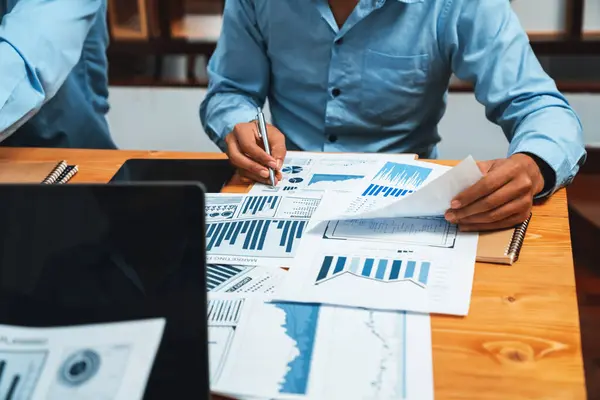 オフィステーブル上の財務データレポートの論文を分析するビジネスアナリストチームの多様なグループ 戦略的マーケティング計画のためのビジネスインテリジェンス分析によるチャートとグラフダッシュボード Habilition — ストック写真