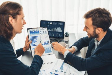 Ofisteki analist ekibi, iş performansını artırmak için bilgisayarında grafik ve çizelge olan BI gösterge panelini kullanarak çalışma alanındaki pazarlama stratejisi için finansal veri analizi yapmakla meşgul. Varlık