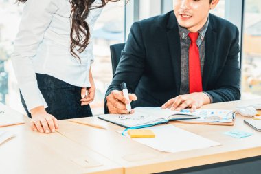 İki iş adamı toplantı odasında proje stratejisi hakkında konuşuyor. İş adamı, iş yerinde iş arkadaşlarıyla proje planlamasını tartışırken aynı zamanda mali raporla ilgili sohbet ve tavsiyelerde bulunuyor. Jivy