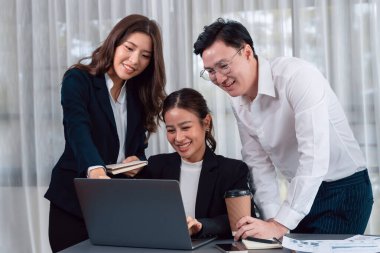 Harmony in office concept as business people analyzing dashboard paper together in workplace. Young colleagues give ideas at manager desk for discussion or strategy planning about project.