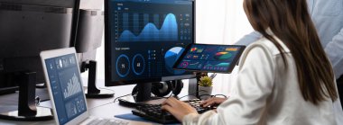 Analizci veri analizi ya da bilgisayar monitöründeki BI gösterge paneli üzerinde çalışıyor. Ticari pazarlama ve strateji planlaması için Fintech 'in şirket ofisindeki finansal verilerini analiz eden iş ekibi. Önde.