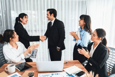 Bir grup iş adamı başarılı bir iş anlaşması toplantısı yaptıktan sonra el sıkıştı. Çeşitli yarış bürosu çalışanları şirket ofisinde pazarlama planlamasında ilerleme kaydettikten sonra kutlama yapıyorlar. Çok titiz.