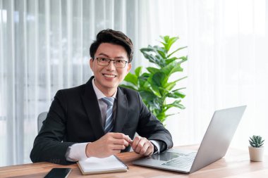 Ofis masası çalışma alanı portresi için dizüstü bilgisayarda çalışan bir iş adamı. Akıllı yönetici finansal iş verilerini araştırıyor ya da masada bilgisayarla stratejik iş pazarlaması planlıyor. Sevinçli.