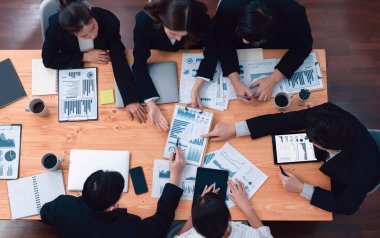 Top-view business team of financial data analysis meeting with business intelligence, report paper and dashboard on laptop for marketing strategy. Business people working together in office of harmony