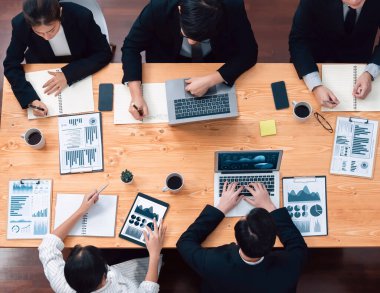 Top-view business team of financial data analysis meeting with business intelligence, report paper and dashboard on laptop for marketing strategy. Business people working together in office of harmony