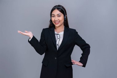 Kulaklık takan kadın çağrı merkezi operatörü ve resmi takım elbiseli. Ürün reklamı için el hareketi yapıyor. Ya da izole bir arka planda insan kaynakları işe alıyor. Sevinçli.