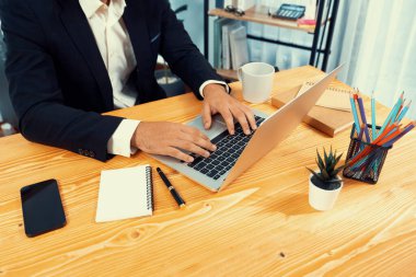 Modern ofis masasındaki modern profesyonel iş adamı çalışmak ve notlar yazmak için dizüstü bilgisayar kullanıyor. Ofisinde bilgisayar defteri üzerinde çalışan çalışkan bir ofis çalışanı. coşkulu