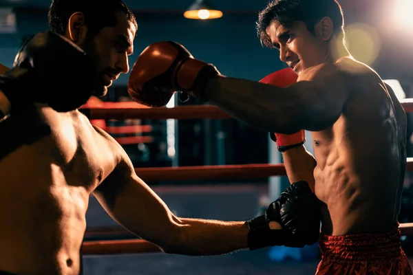 アジア人と白人ムエタイのボクサーは激しいボクシング試合で力を発揮します 力強い筋肉質のボクサーがパンチとストライキを容赦ない戦闘力で交換 インペトゥス — ストック写真