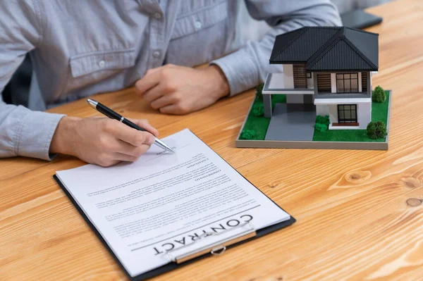 New home owner signing house loan or rental lease contract after agreeing to term and condition with real estate agent. Contract document with clients signature as housing business concept. Entity