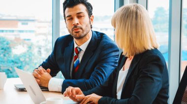 İki iş adamı toplantı odasında proje stratejisi hakkında konuşuyor. İş adamı, iş yerinde iş arkadaşlarıyla proje planlamasını tartışırken aynı zamanda mali raporla ilgili sohbet ve tavsiyelerde bulunuyor. Jivy