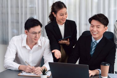 Harmony in office concept as business people analyzing dashboard paper together in workplace. Young colleagues give ideas at manager desk for discussion or strategy planning about project.