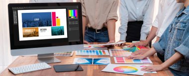 Grafik tasarımcı logo ve grafik sanatları yoğun sanat atölyesinde, dizüstü bilgisayar gösterim atölyesinde. Yaratıcı tasarım için renk paleti ve desen deneniyor. Panorama çekimi. İnceleyin