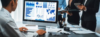 İş zekası ve veri analizi kavramı. Analizci ekibi laptop ekranında finansal veri analizi üzerinde çalışıyor. Etkili iş stratejik planlama için pazarlama göstergesi olarak. İçgörü