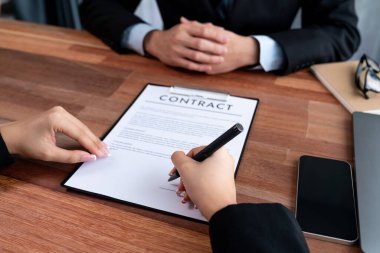 Yöneticiler toplantı odasında sözleşme imzalarlar. İş adamları anlaşmayı kağıda döker. Yasal belgeyi imzalayan iki iş ortağı arasında başarılı bir anlaşma. Sevinçli.