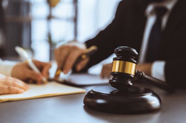 Hukuk bürosu masasında çalışan ya da yasal belge hazırlayan avukat meslektaşları ya da hukuk ekibi. Gavel, kanun koyucu ve avukatın adil ve eşit karar vermesi için çekiç. Eşitlik