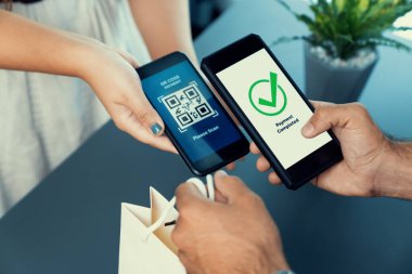 Parasız ödeme taraması için QR kodu ekranda görüntülendi. Kapalı eller, mobil uygulamadan elektronik işlem yoluyla para aktarmak için akıllı telefonu tutuyor. Hızlı ödeme için barkod teknolojisi. Coşkulu