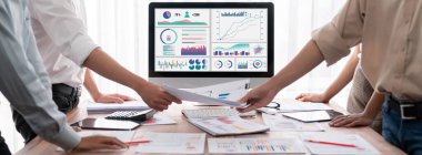 Analist ekibi, FBI Fintech 'i kullanarak mali konsolu inceliyor ve işaret ediyor. İş adamları iş görüşü için raporları inceliyor. Panorama çekimi. İnceleyin