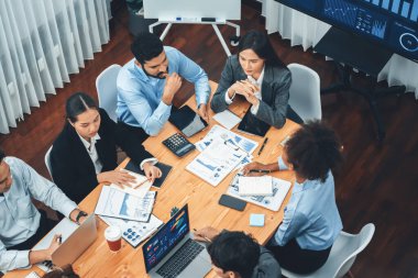 Çok ırklı analist ekibi toplantıdaki finansal verileri analiz etmek için BI Fintech yazılımı kullanıyor. Üst görünüm finans paneli veri ekranında pazarlama göstergesi için analiz edilmiş grafikle birlikte. Uyum