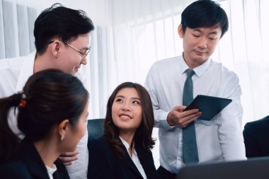 Harmony in office concept as business people analyzing dashboard paper together in workplace. Young colleagues give ideas at manager desk for discussion or strategy planning about project.