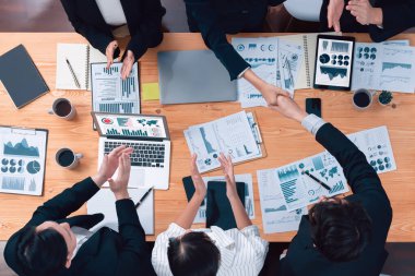 Top-view business team of financial data analysis meeting with business intelligence, report paper and dashboard on laptop for marketing strategy. Business people working together in office of harmony