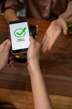QR kodu parasız ödeme taraması için ekranda gösterilir. Kapalı eller, mobil uygulamadan elektronik işlem yoluyla para aktarmak için akıllı telefonu tutuyor. Hızlı ödeme için barkod teknolojisi. Coşkulu.