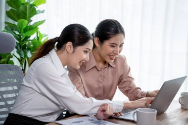 Modern ofis çalışma alanında iş birliği yapan iki genç ofis çalışanı, modern ofis çalışanı olarak profesyonelliklerini sergileyerek, dizüstü bilgisayarda tartışıyorlar ve birlikte çalışıyorlar. Coşkulu.