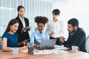 Çok ırklı analist ekibi toplantı masasındaki mali raporu analiz etmek için BI gösterge tablosunu kullanıyor. Çeşitli iş adamlarından oluşan bir grup, FIntech 'in veri analizini başarılı iş pazarlaması için kullanır. Uyum