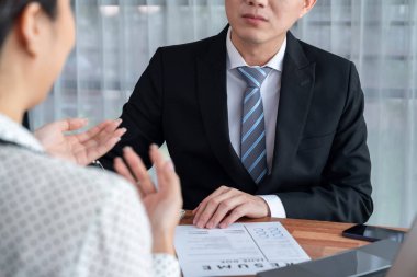 Görüşmeci ve aday arasındaki iş görüşmesi. İK müdürü aday niteliklerini ve özgeçmişli iş başvurusunu soruyor. Başvuru sahibinin işi. Sevinçli.