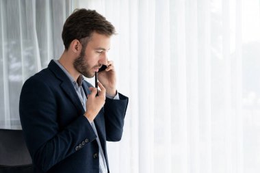 Çalışkan iş adamı, modern ofiste güvenilir bir şekilde müşteriye ikna edici satış çağrıları yapıyor. Ofis çalışanı telefonda konuşuyor ve iş arkadaşlarıyla iş görüşmesi yapıyor. Varlık