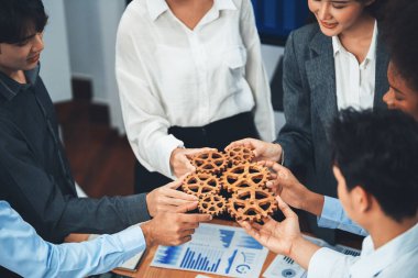 Ofis çalışanı çarkları birlik ve sistem takım çalışması olarak tutuyor. Şirket işyerinde, bir yığın iş kağıdı ve mali raporla toplantı masasında. Ticari başarıları olan iş adamları. Uyum