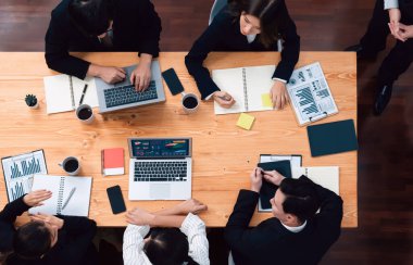 Top view manager or office worker give presentation in harmony conference room to business colleague, BI data dashboard on screen and pile of financial analyzed data reports on meeting table.