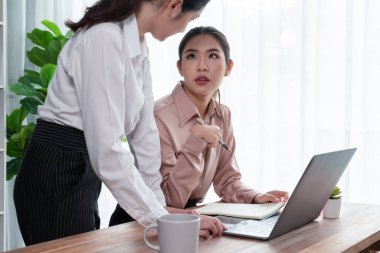 Modern ofis çalışma alanında iş birliği yapan iki genç ofis çalışanı, modern ofis çalışanı olarak profesyonelliklerini sergileyerek, dizüstü bilgisayarda tartışıyorlar ve birlikte çalışıyorlar. Coşkulu.