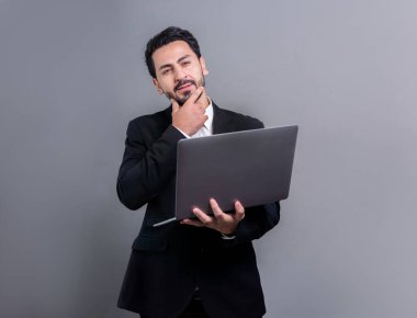 Yenilikçi teknoloji kavramına sahip başarılı bir iş adamı, ayakta duran, dizüstü bilgisayarı tutan ve telif alanı arka planında reklam ya da tanıtım için heyecanla gülümseyen. Coşkulu