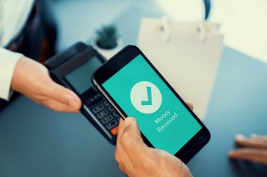 NFC QR kod cihazı ile el ele tutuşan akıllı telefon, hızlı dijital işlemler için temas kurulamayan ödeme kodlarını tarıyor. Modern yaşam tarzı ödeme teknolojisi için cep telefonundaki online bankacılık uygulaması. coşkulu