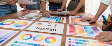 Grafik tasarımcı beyin fırtınası logosu ve grafik sanat yoğun yaratıcı stüdyo atölyesinde. Yaratıcı tasarım için çalışma masasında deney ve beyin fırtınası renk paleti ve desen. Panorama çekimi. İnceleyin