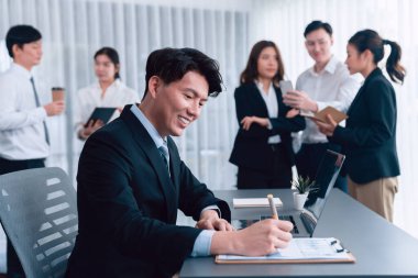 Portrait of focus young successful confident male manager, executive wearing business wear in harmony office arm crossed with blurred meeting background of colleagues, office worker.