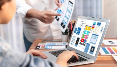 Dizüstü bilgisayar ekranında mobil uygulama için UI ve UX tasarımları tasarlayan ön uç geliştirici ekibin panorama görüntüsü. Kullanıcı dostu UI tasarımı için kullanıcı arayüzü geliştirme ekibi planlama. İnceleyin