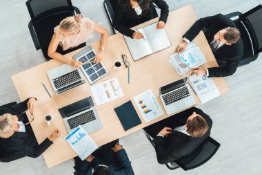 İş adamları grup toplantısı ofiste yukarıdan çekildi. İş kadınları, iş adamları ve ofis çalışanları toplantı masasında proje planlama belgeleriyle takım konferansında çalışıyorlar. Jivy