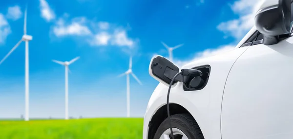 从可再生能源驱动的公共充电站的模糊背景出发 聚焦与电动汽车充电器相连的特写电动车 促进友好环保的汽车理念 — 图库照片