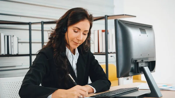 stock image Business people wearing headset working in office to support remote customer or colleague. Call center, telemarketing, customer support agent provide service on telephone video conference call. Jivy