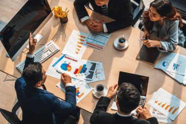 İş adamları grup toplantısı ofiste yukarıdan çekildi. İş kadınları, iş adamları ve ofis çalışanları toplantı masasında proje planlama belgeleriyle takım konferansında çalışıyorlar. Jivy