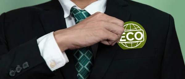 Eco-friendly corporate promoting sustainable and green business concept with businessman hold ECO symbol paper as environmental protection commitment using clean energy with zero CO2 emission. Alter