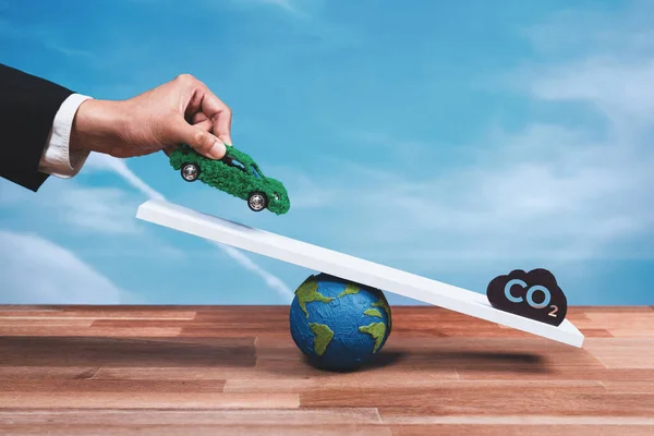 商人将环保电动车与二氧化碳符号进行了比例尺 推广了企业零排放汽车 可持续和平衡的绿色环境方法 零净排放车辆 改变了 — 图库照片
