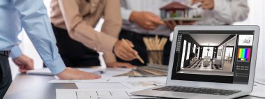 İç mimar tasarımcı grubu, daha kesin tasarım için planlar ve dizüstü bilgisayar ekran mimari yazılımı üzerinde birlikte tartışıyorlar. Modern ev tasarımı ve yenileme. İçgörü