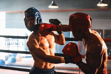 Kasklı iki atletik ve kaslı vücut boksörü ya da boks baş muhafızı vahşi bir boks maçında karşı karşıya. Boks dövüşçüsü boks ringinde dövüşüyor. Impetus
