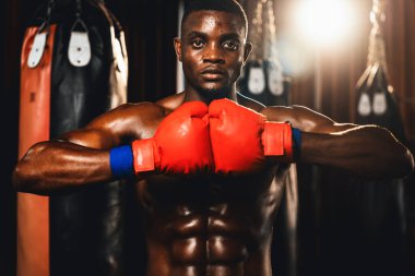 Boks dövüşçüsü, Afro-Amerikan siyah boksör elini veya yumruğunu agresif bir duruşla öne koydu ve boks çantası ve boks ekipmanıyla spor salonunda dövüşmeye hazırdı. Impetus