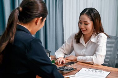 Temsilciyle ev kredisi sözleşmesini gözden geçiriyorum. Mali belgeleri ve vergi oranlarını, mülkiyet sahibi olmak için hesap makinesiyle analiz ediyorum. Yeni ev alımı ve finansman için anahtar imza. Coşkulu.