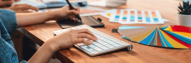 Grafik tasarımcısı, modern dijital stüdyo işyerinde profesyonel grafik ekibiyle benzersiz bir tasarım yaparken bilgisayar dizüstü bilgisayar ve grafik çizim kalemi üzerinde çalışır. Panorama çekimi. İnceleyin